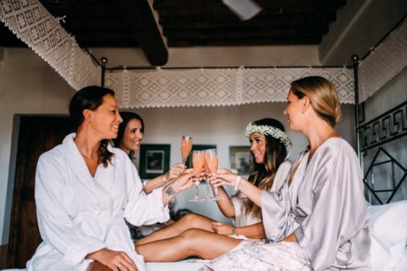 Bride and bridesmaids toasting while getting ready