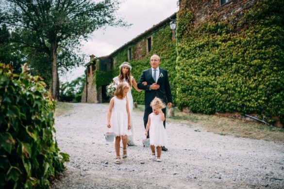 Father of the bride brings his daughter to ceremony with 2 bridesmaids