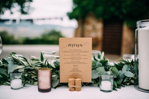 Detail of wedding table with candles, menu and eucalyptus garland