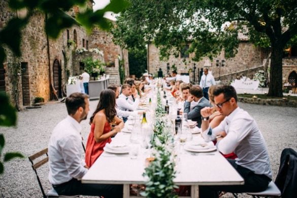 Guests at wedding dinner table courtyard Tuscan borgo