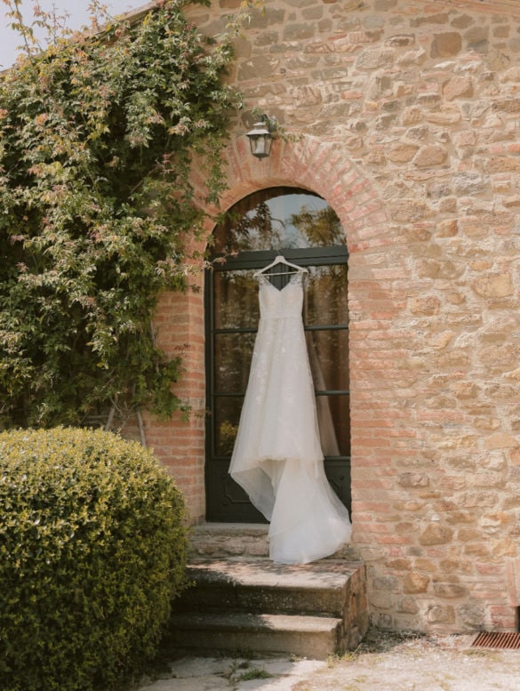 Romantic wedding dress in lace with long train waiting to be put on.