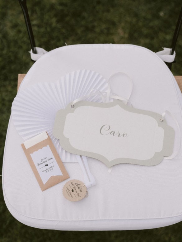 Hand fan, tissue and place card for guestst at ceremony setting.