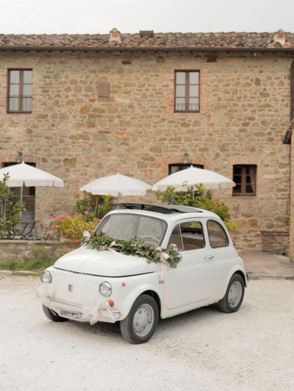 Off white vintage Fiat 500 with ribbons is ready for the wedding day.