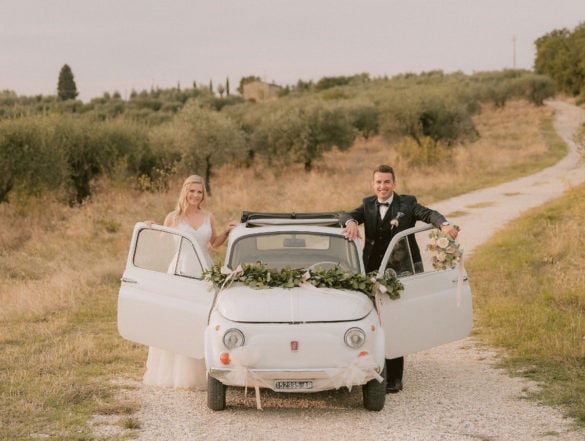 German wedding couple with vintage Fiat 500 in olive grove in Tuscany