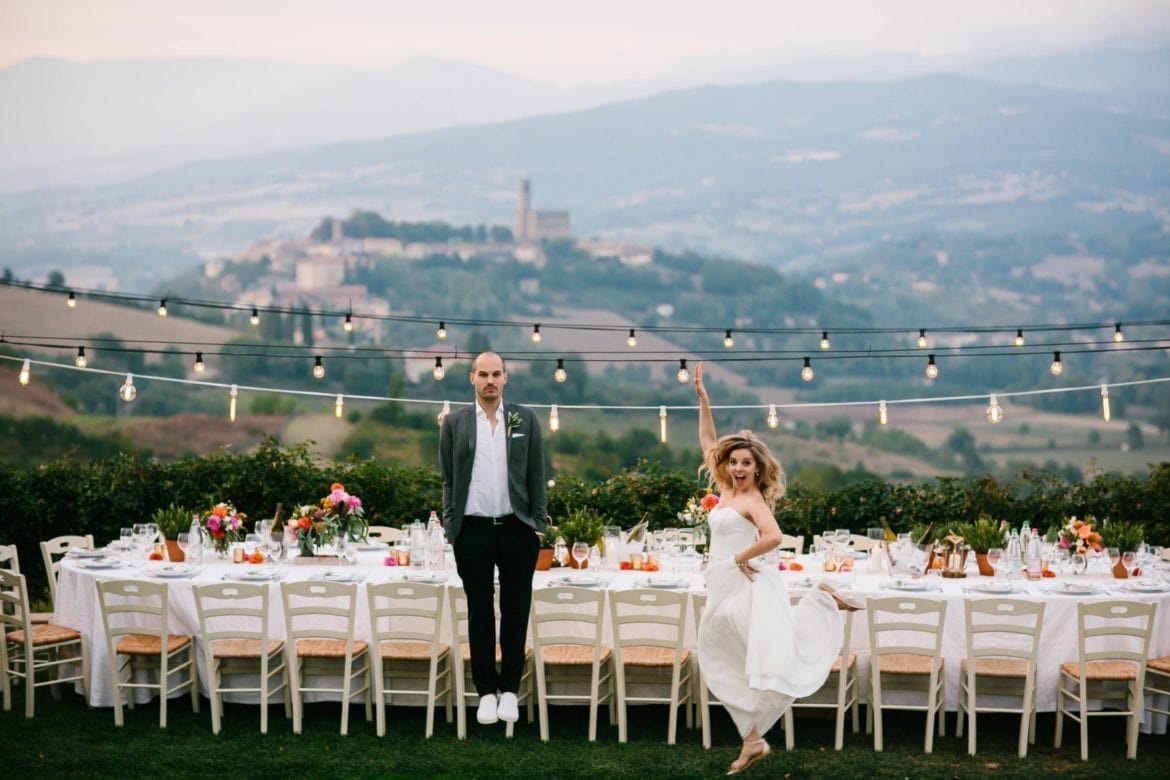 Bruid en bruidegom voor dinertafel buiten in de Toscaanse heuvels