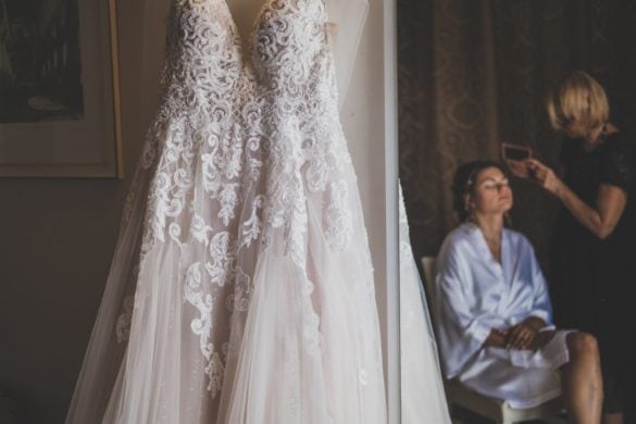 Detail of wedding dress and make up artist while bride is getting ready.