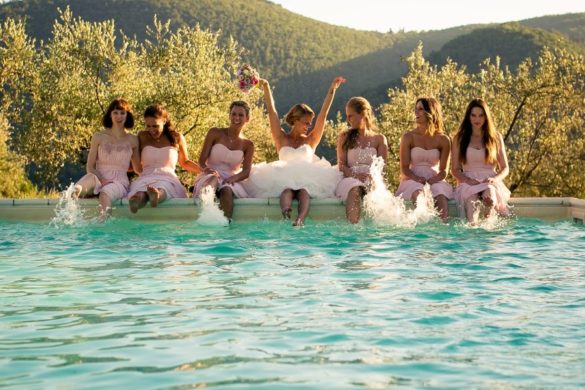 Lustiges Hochzeitsfoto der Braut und der Brautjungfern am Pool einer privaten Villa in der Toskana