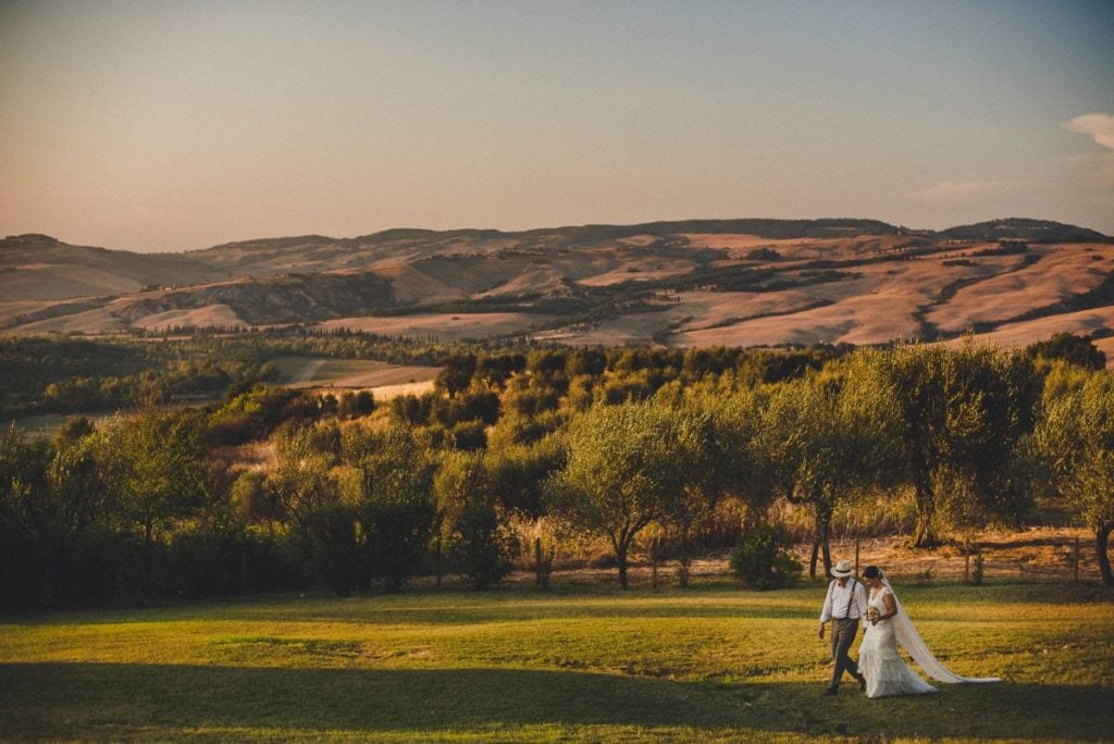 Bride and groom at gorgeous wedding location with panoramic view in Val d'Orcia