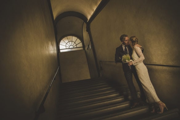 Groom kisses bride on steps of Palazzo Vecchio