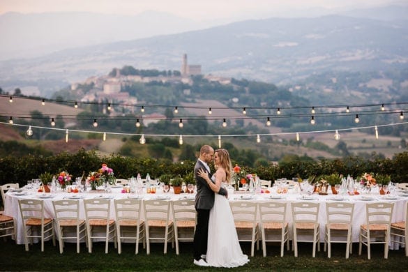 wunderschöner Hochzeitstisch in der Toskana mit Panoramablick und Partylichtern.