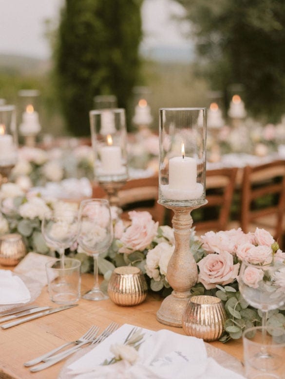 Elegant wedding dinner decoration with candle holders and blush colored flower garland.